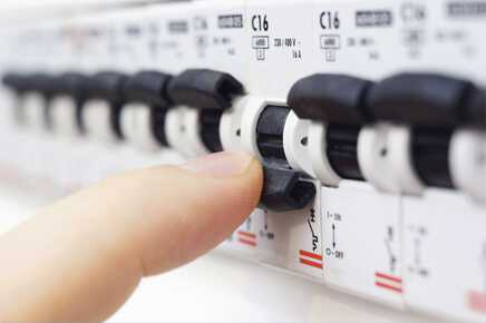 About Us page image - Hand operating a power panel switch - image for About Us page
