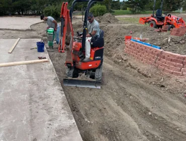 A man operating machine to flatten the ground