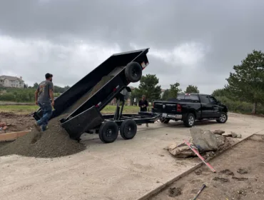 Black truck pouring sand in our work page